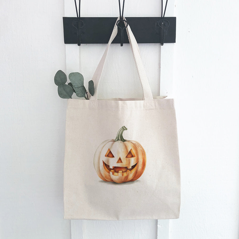 A stylish Watercolor Carved Pumpkin canvas tote bag featuring a vibrant pumpkin design, perfect for eco-friendly shopping.