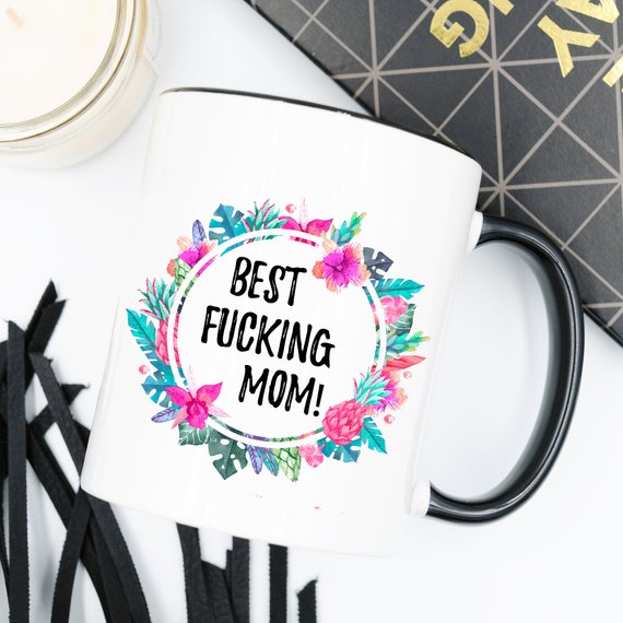 A white ceramic mug with the phrase 'Best Fucking Mom' printed in vibrant colors on both sides, showcasing its high-quality design.