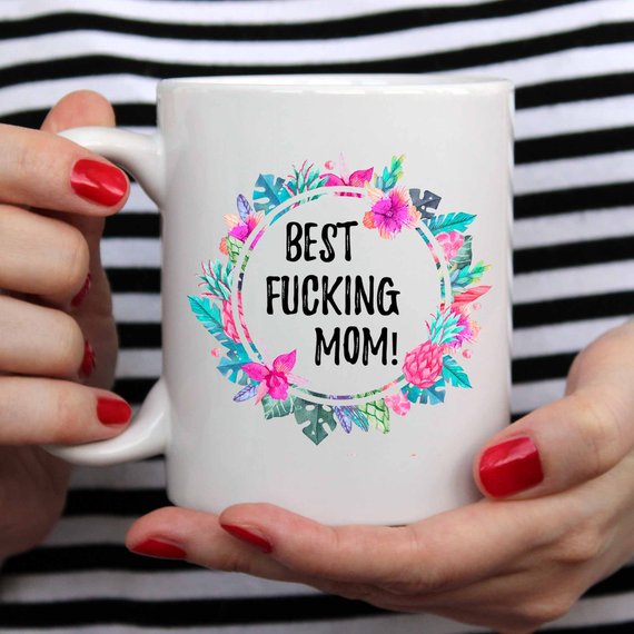 A white ceramic mug with the phrase 'Best Fucking Mom' printed in vibrant colors on both sides, showcasing its high-quality design.