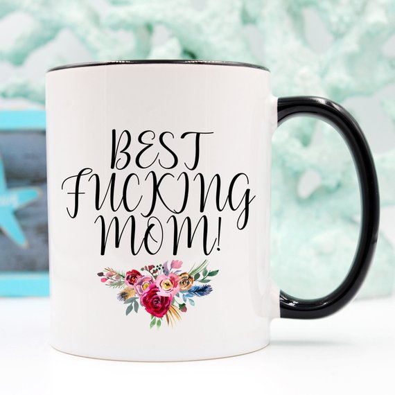 A white ceramic mug with the phrase 'Best Fucking Mom' printed in vibrant colors on both sides, showcasing a humorous and heartfelt design.