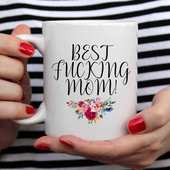 A white ceramic mug with the phrase 'Best Fucking Mom' printed in vibrant colors on both sides, showcasing a humorous and heartfelt design.