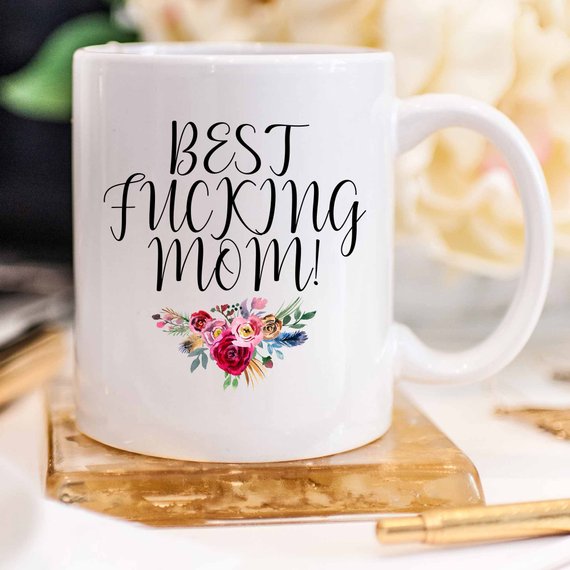 A white ceramic mug with the phrase 'Best Fucking Mom' printed in vibrant colors on both sides, showcasing a humorous and heartfelt design.