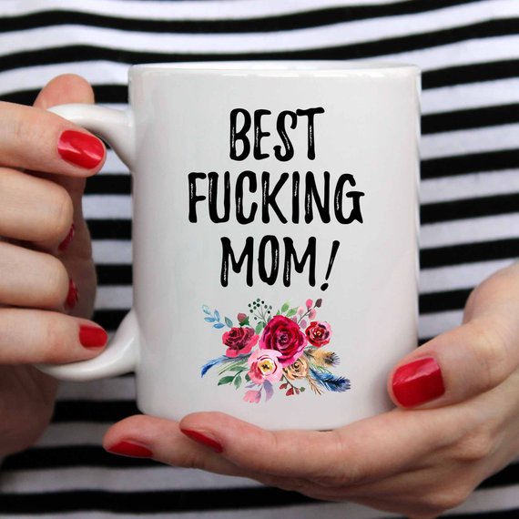 A white ceramic mug with 'Best Fucking Mom' printed in vibrant colors on both sides, showcasing a humorous and heartfelt design.