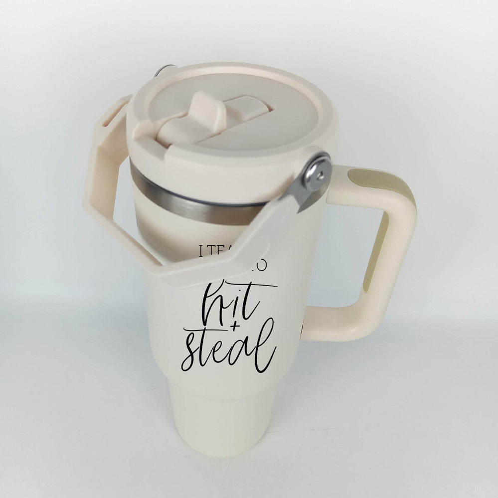 Hit & Steal tumbler with cream exterior and stainless steel interior, featuring a humorous design for baseball moms, double handles, and a no-spill sipping spout.