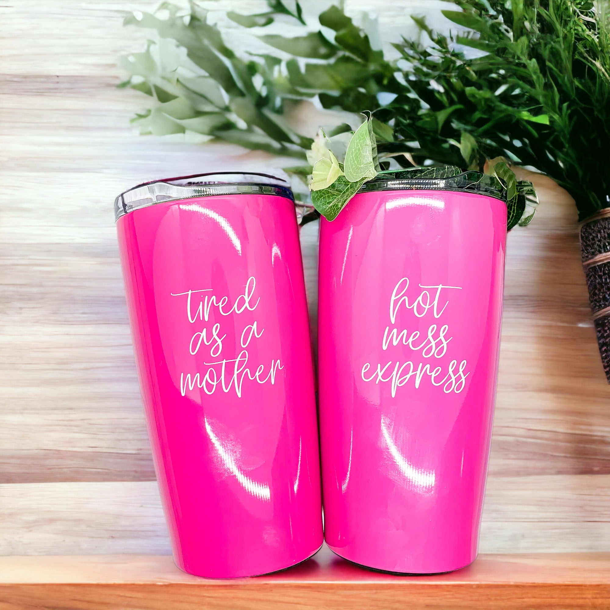 Two pink tumblers with text.