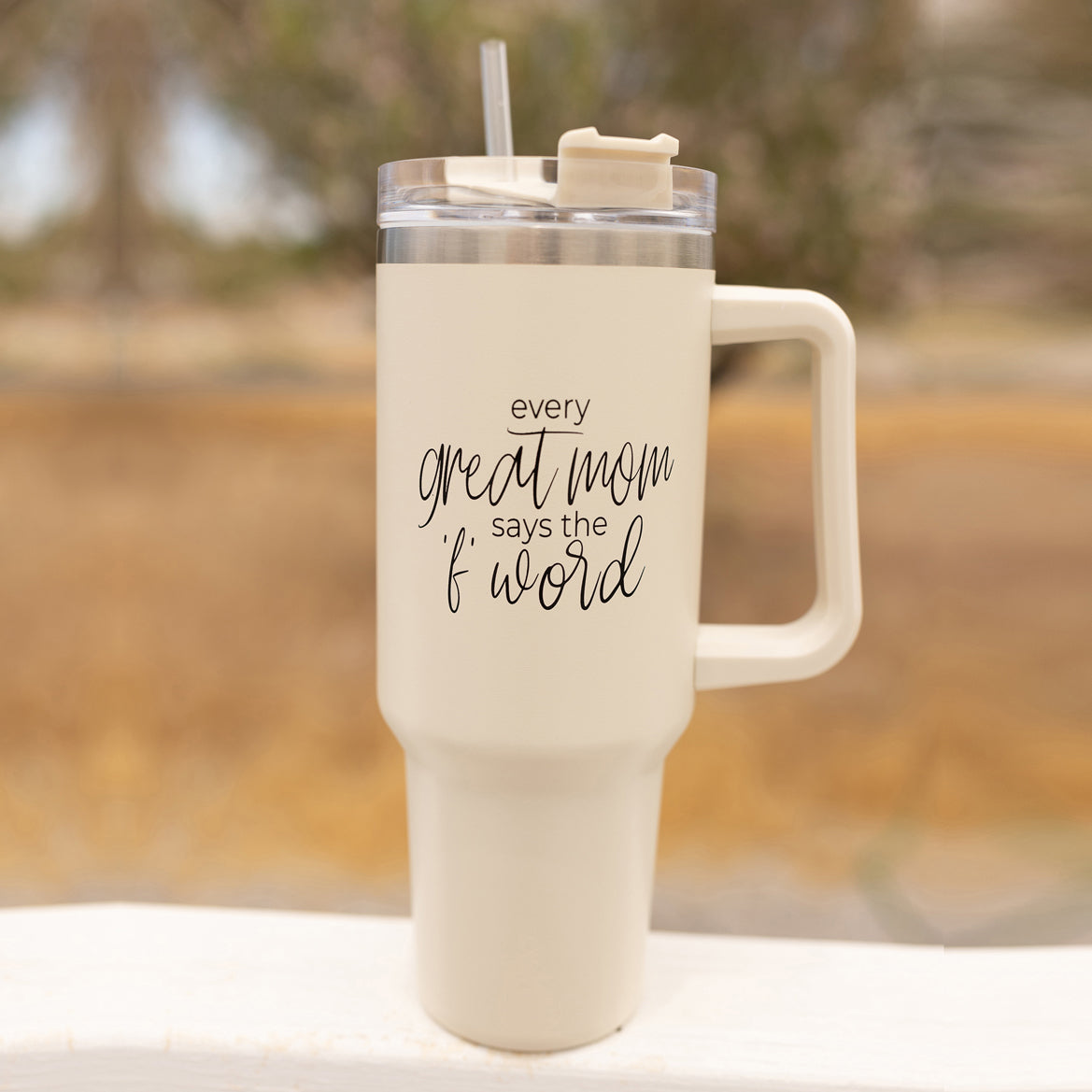 Mom Says the F Word 40oz insulated mug with a matte cream finish, featuring a black graphic design, a removable 3-in-1 lid, and a plastic straw.