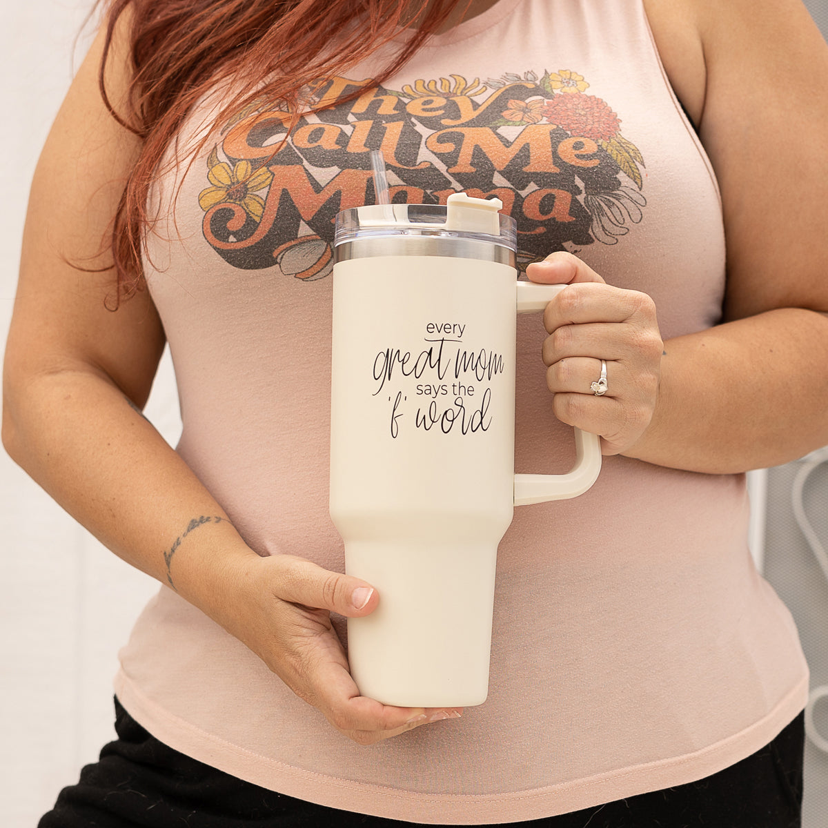 Mom Says the F Word 40oz insulated mug with a matte cream finish, featuring a black graphic design, a removable 3-in-1 lid, and a plastic straw.