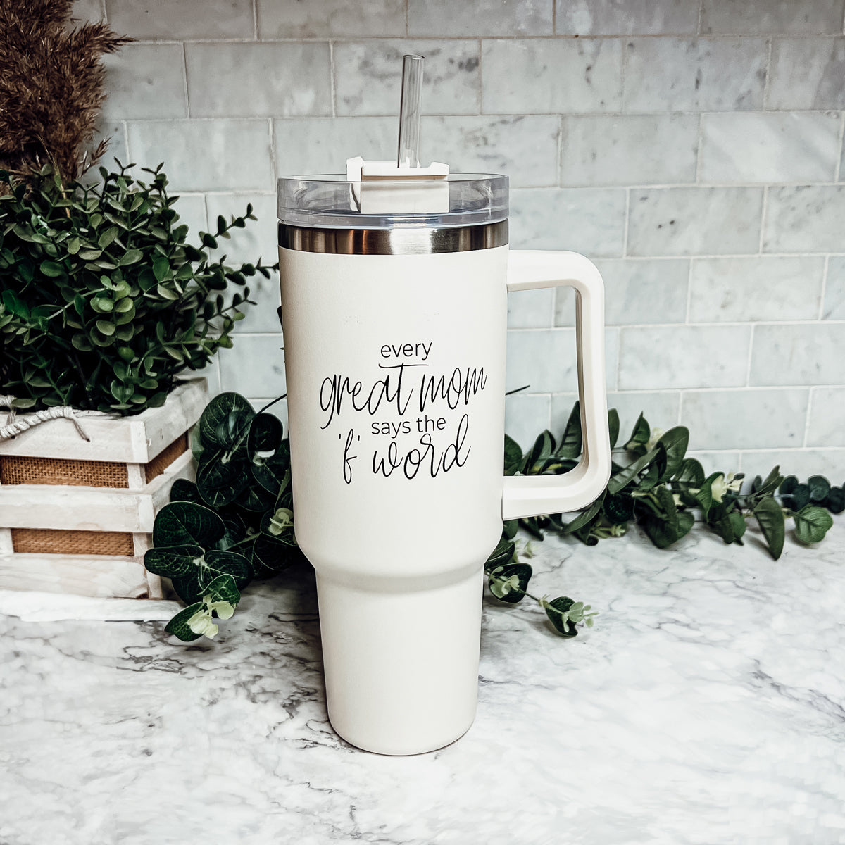 Mom Says the F Word 40oz insulated mug with a matte cream finish, featuring a black graphic design, a removable 3-in-1 lid, and a plastic straw.