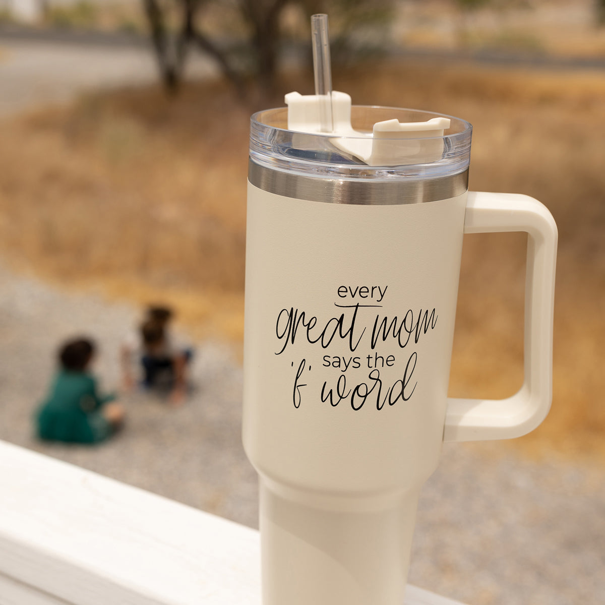 Mom Says the F Word 40oz insulated mug with a matte cream finish, featuring a black graphic design, a removable 3-in-1 lid, and a plastic straw.