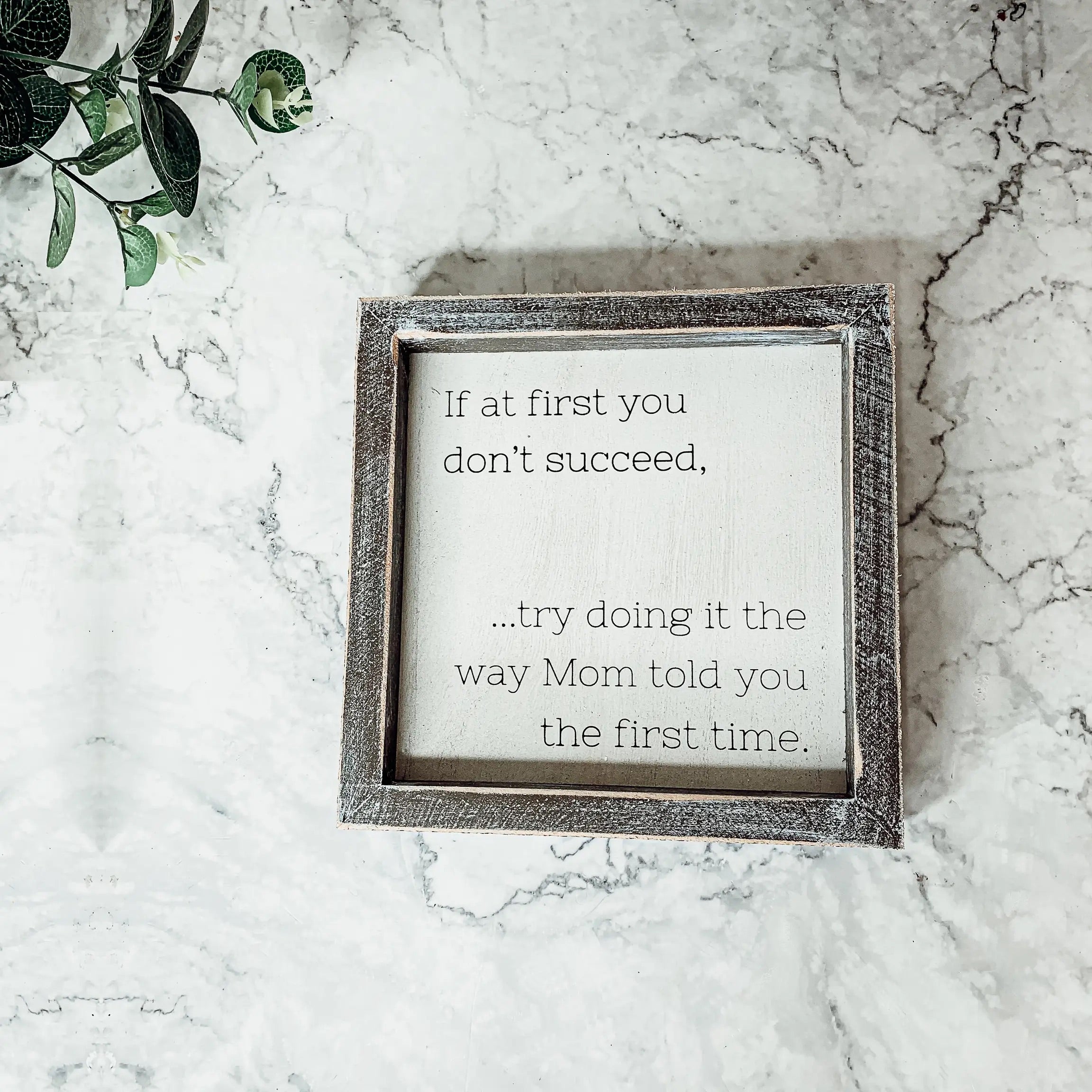 A wooden sign framed in wood, measuring 7x7 inches, featuring a humorous quote about motherhood, suitable for wall hanging or standing display.