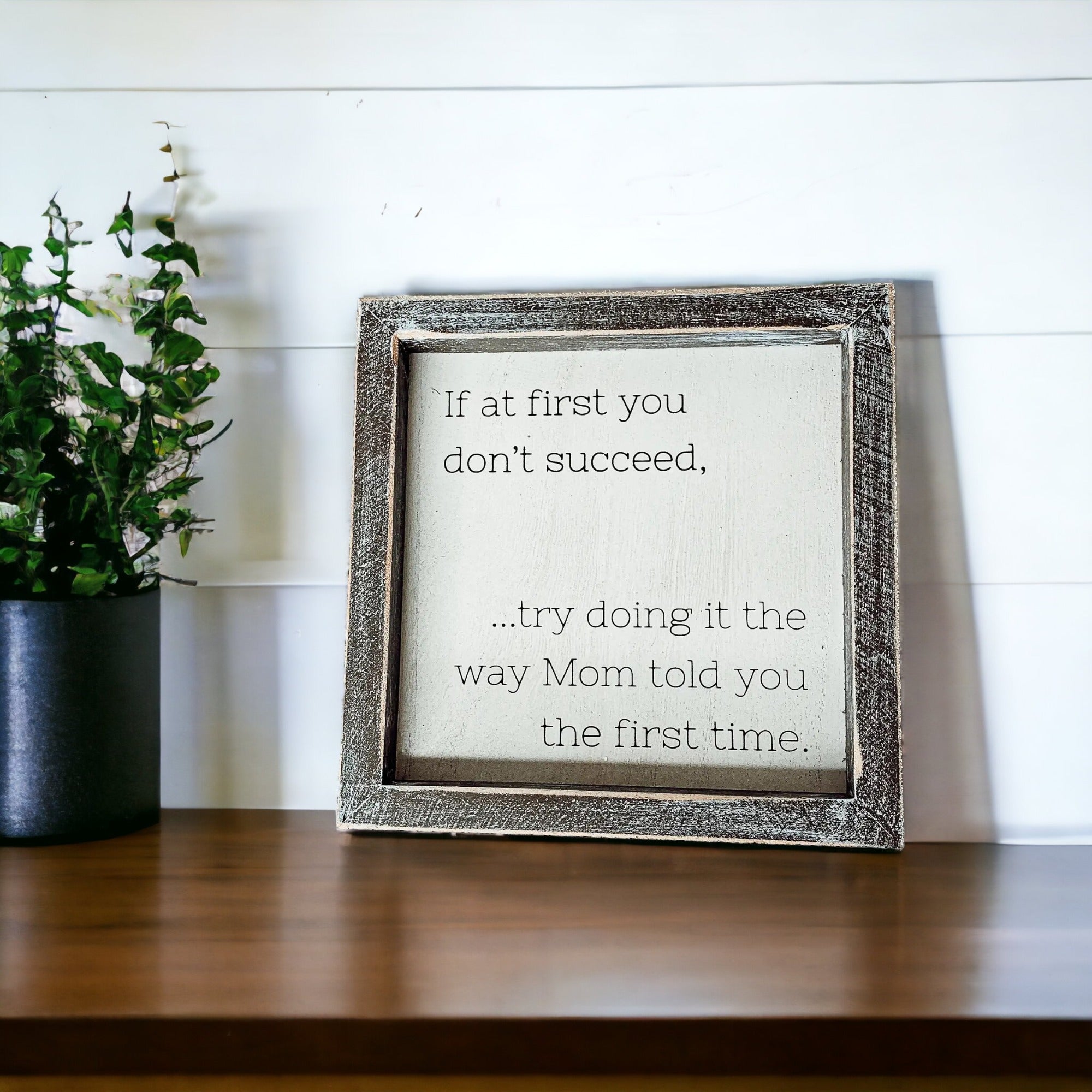 A wooden sign framed in wood, measuring 7x7 inches, featuring a humorous quote about motherhood, suitable for wall hanging or standing display.