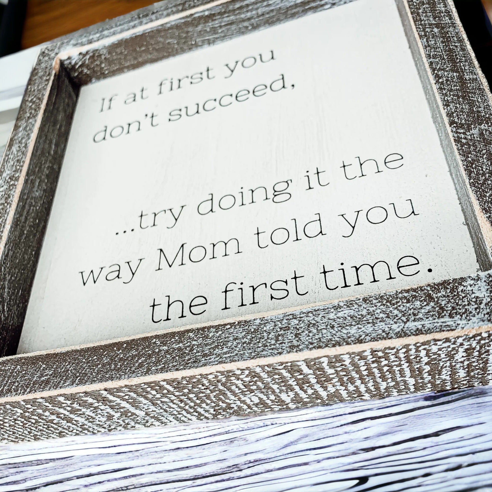 A wooden sign framed in wood, measuring 7x7 inches, featuring a humorous quote about motherhood, suitable for wall hanging or standing display.