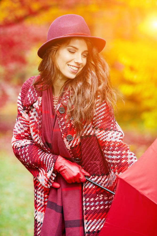 Woman in autumn clothes, smiling.