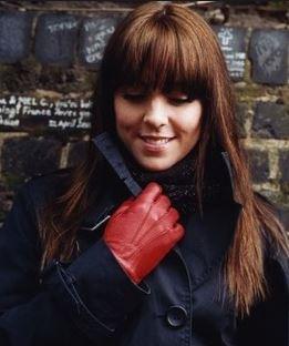 Woman with red gloves smiling.