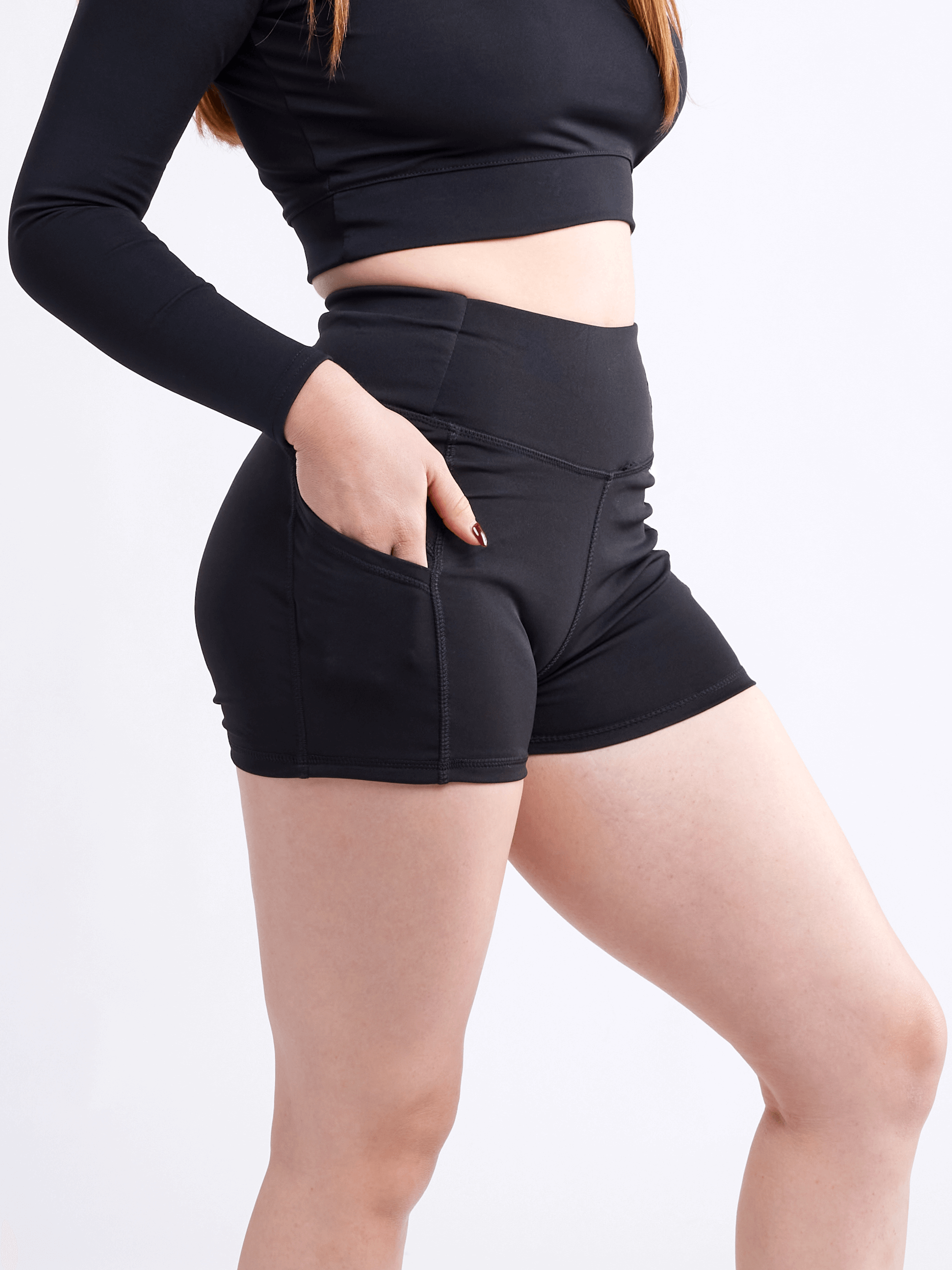 High-waisted athletic shorts for women with side pockets, made from soft polyester/spandex blend, ideal for workouts and casual wear.