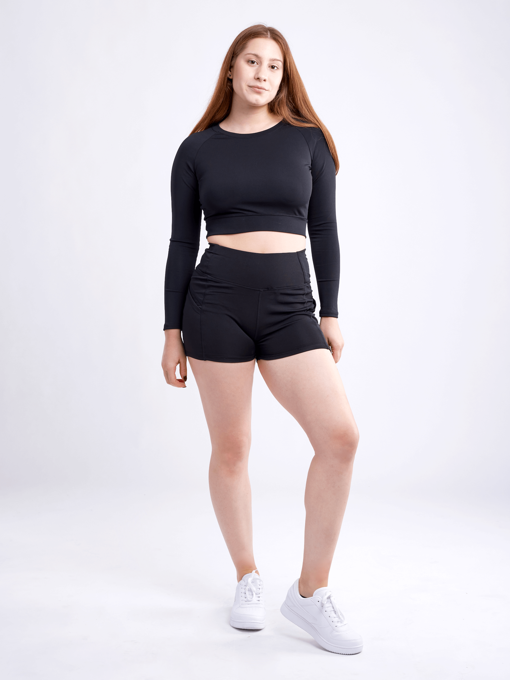 High-waisted athletic shorts for women with side pockets, made from soft polyester/spandex blend, ideal for workouts and casual wear.