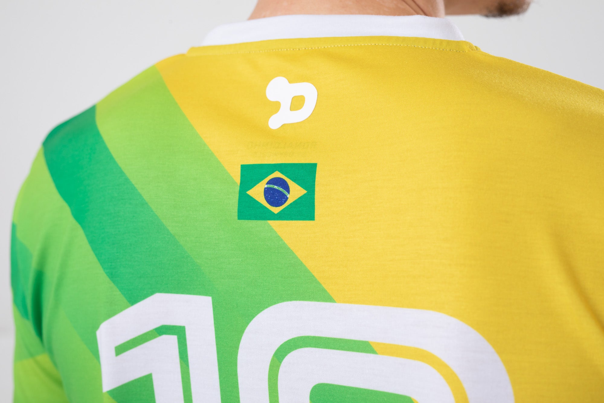 Ronaldinho Brazil Jersey featuring a V-Neck design, woven badge with Ronaldinho's silhouette, and soft polyester/elastane fabric.