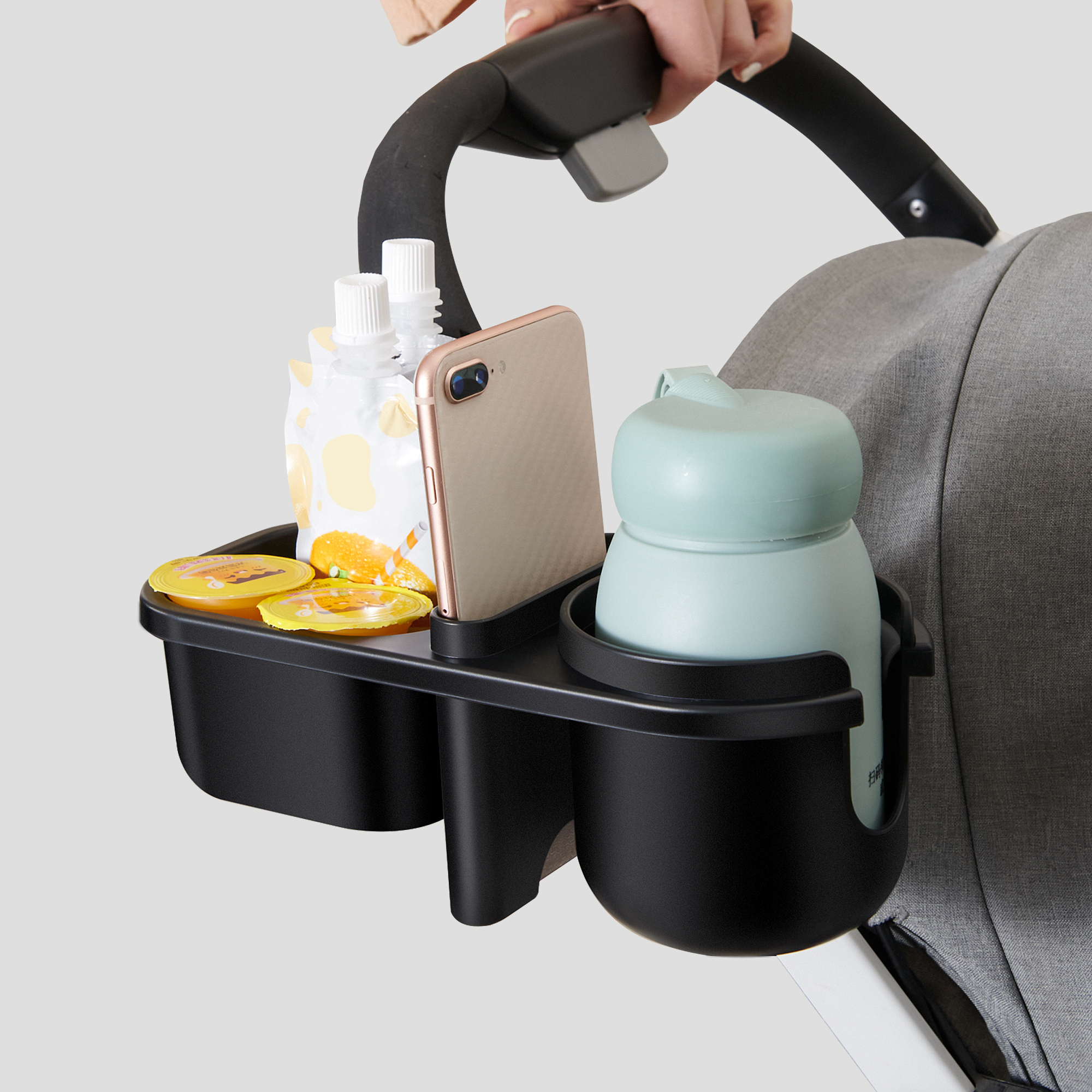 A 3-in-1 Baby Stroller Parent Cup Holder securely holding a drink, phone, and snacks, attached to a stroller, showcasing its adjustable clamp and silicon petals.