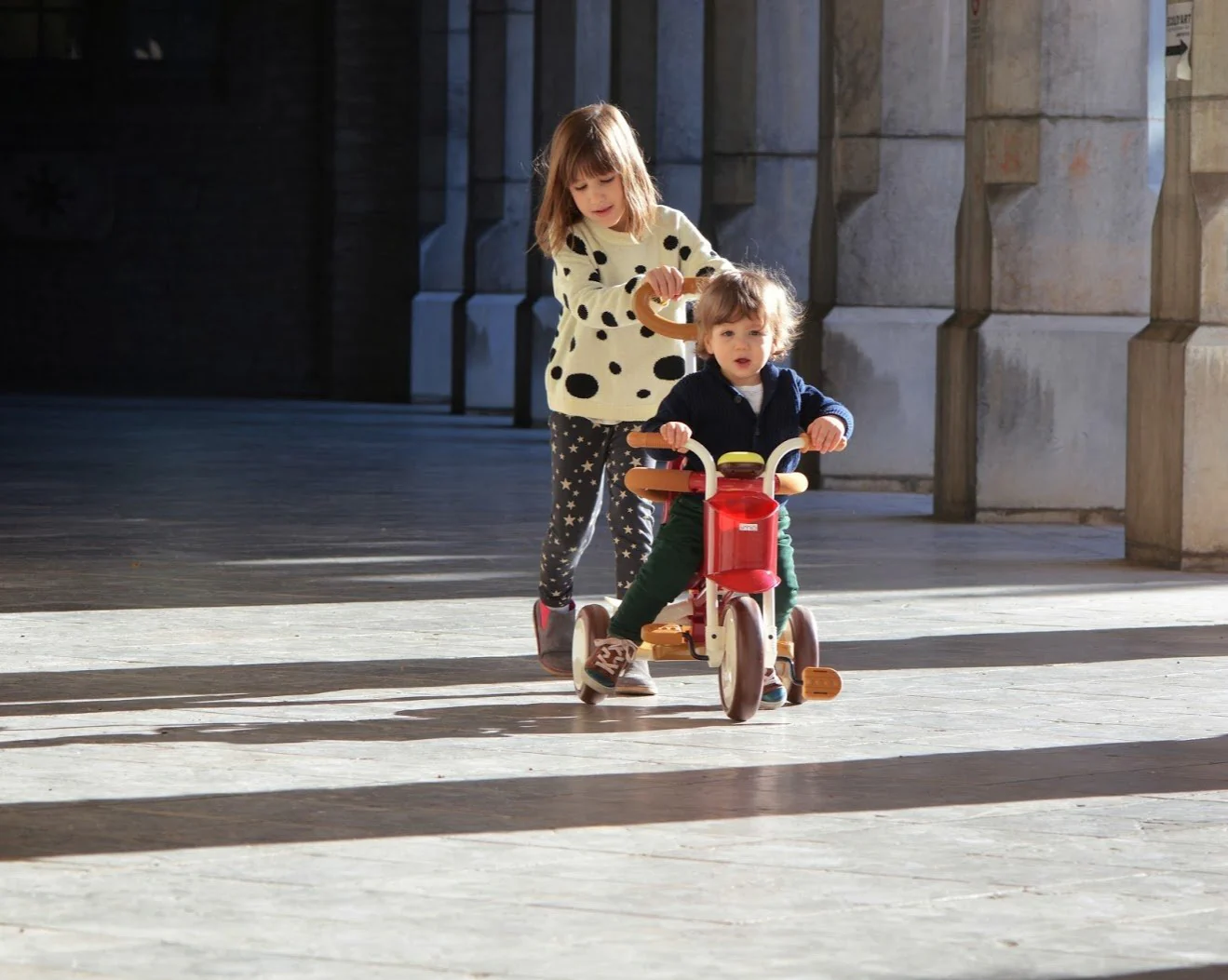 A stylish EVOLUTIVE TRICYCLE designed for kids, featuring a retro look with modern colors, safety bar, adjustable push handle, and comfortable saddle.