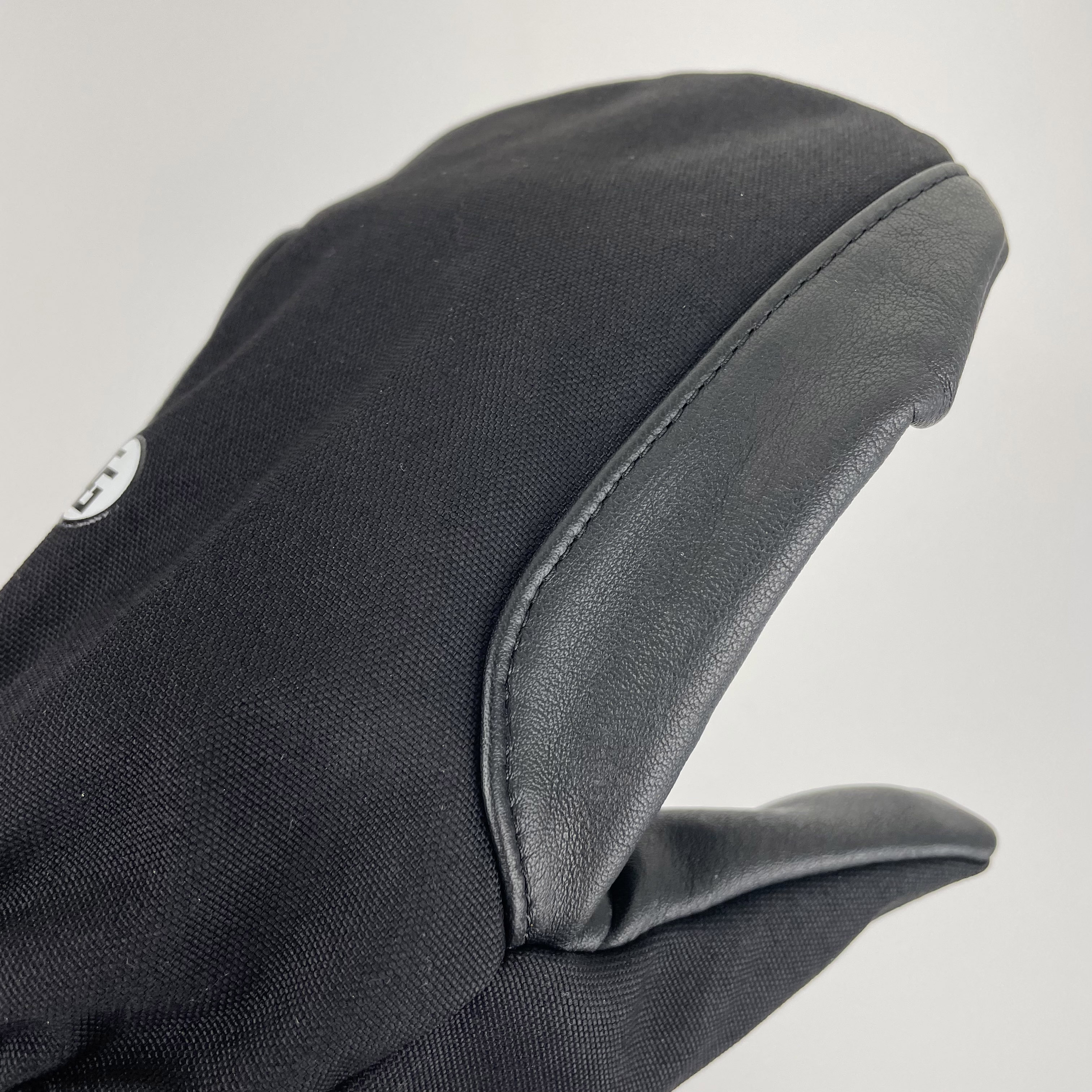 Super Shell Mitten featuring durable cowhide leather palm and ballistic nylon top, designed for outdoor activities and harsh conditions.