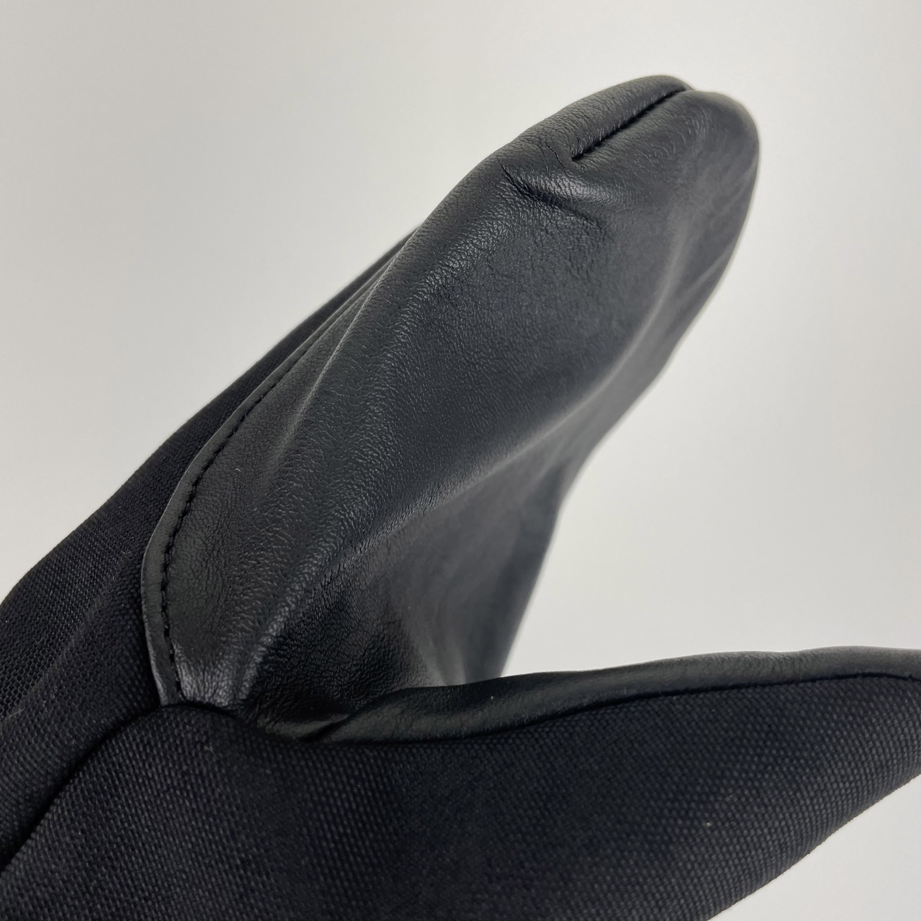 Super Shell Mitten featuring durable cowhide leather palm and ballistic nylon top, designed for outdoor activities and harsh conditions.