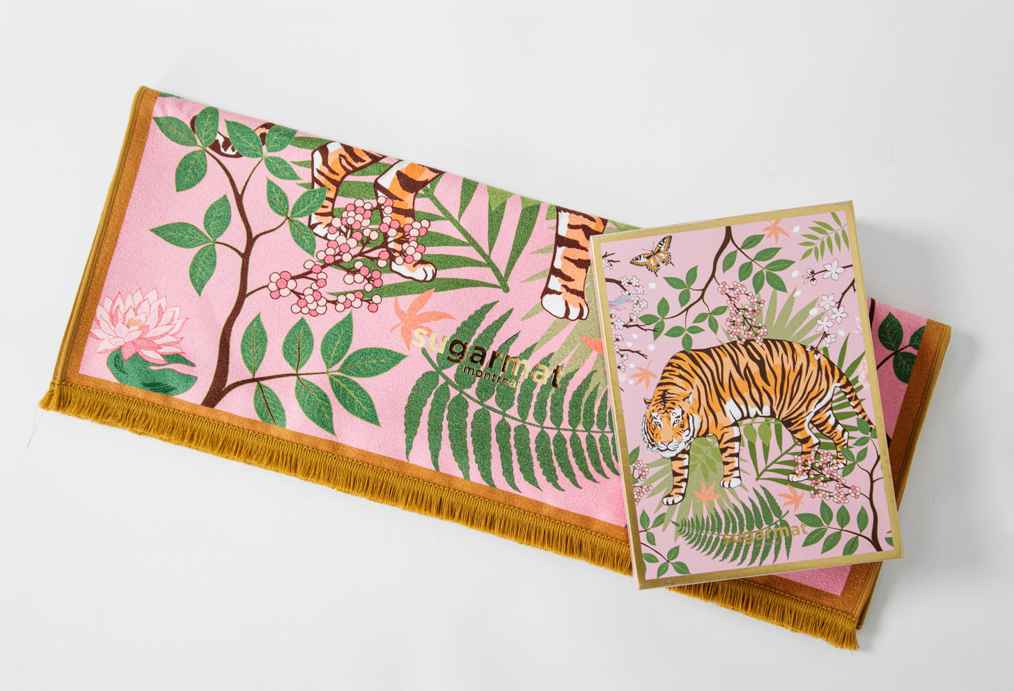 The Striped Charmer yoga towel featuring a majestic feline design surrounded by cherry blossoms, with cute tassels on the edges.