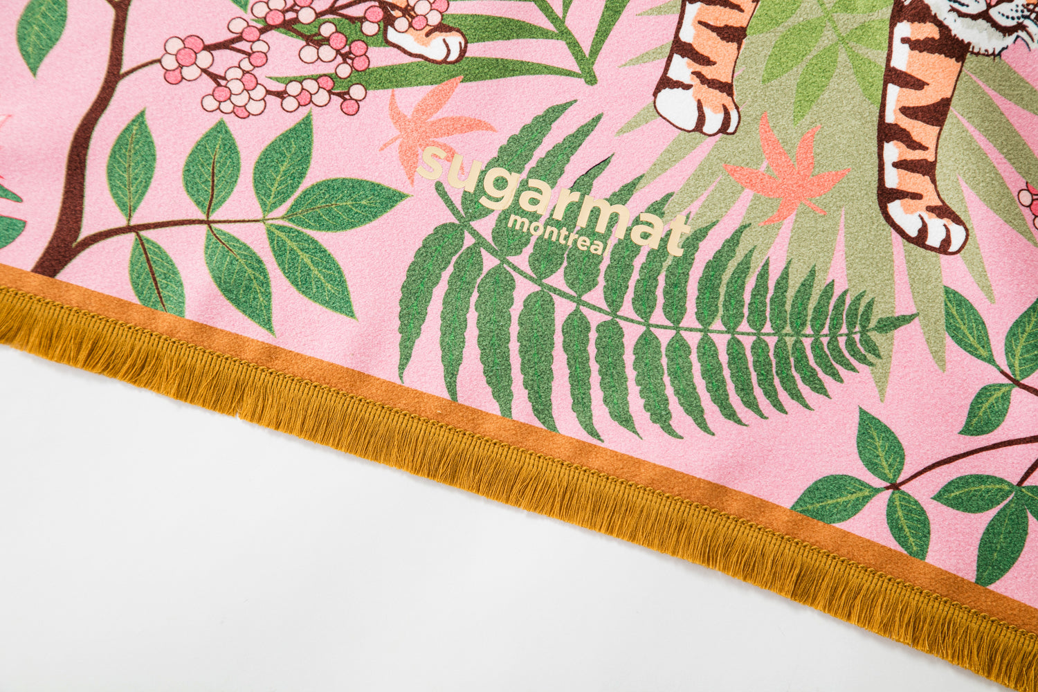 The Striped Charmer yoga towel featuring a majestic feline design surrounded by cherry blossoms, with cute tassels on the edges.