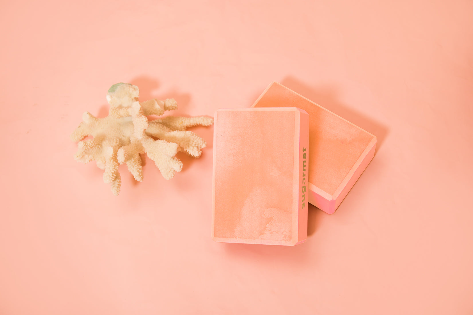 A pink yoga block made of high-density EVA foam, featuring beveled edges for grip, ideal for supporting various yoga poses.