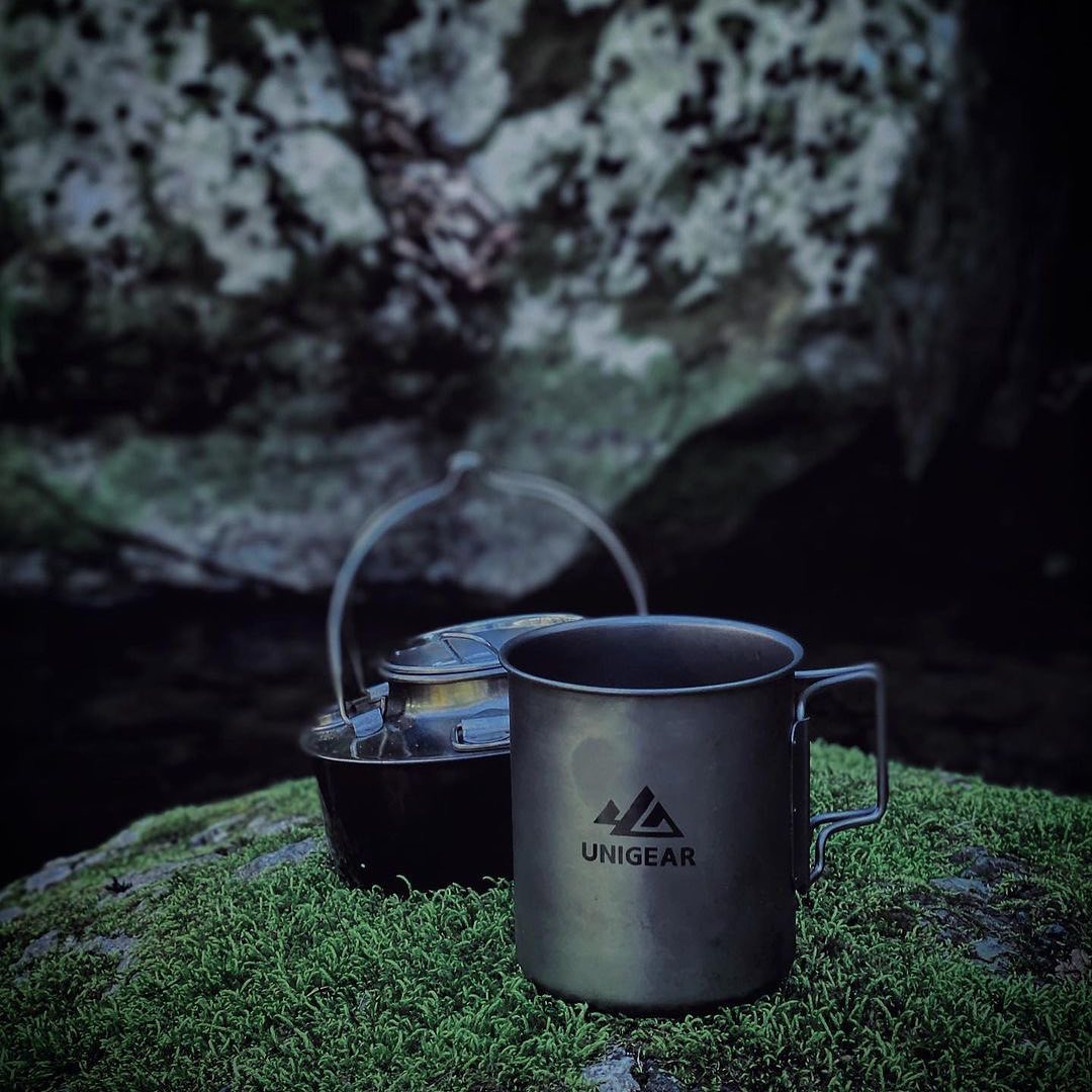 A 100% titanium camping cup with folding handles, showcasing its lightweight and durable design, perfect for outdoor adventures.