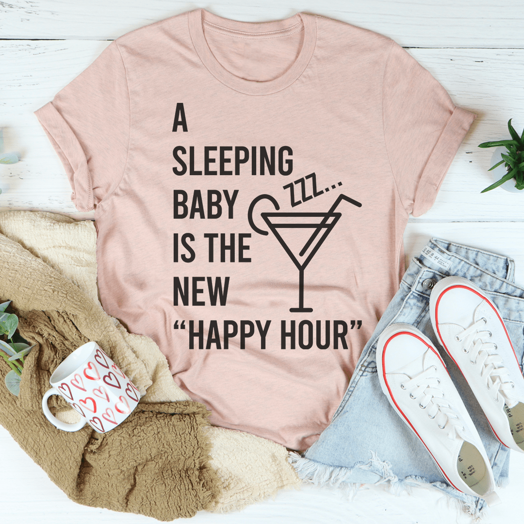 A soft and durable A Sleeping Baby Is The New Happy Hour Tee displayed on a hanger, showcasing its stylish design and quality fabric.