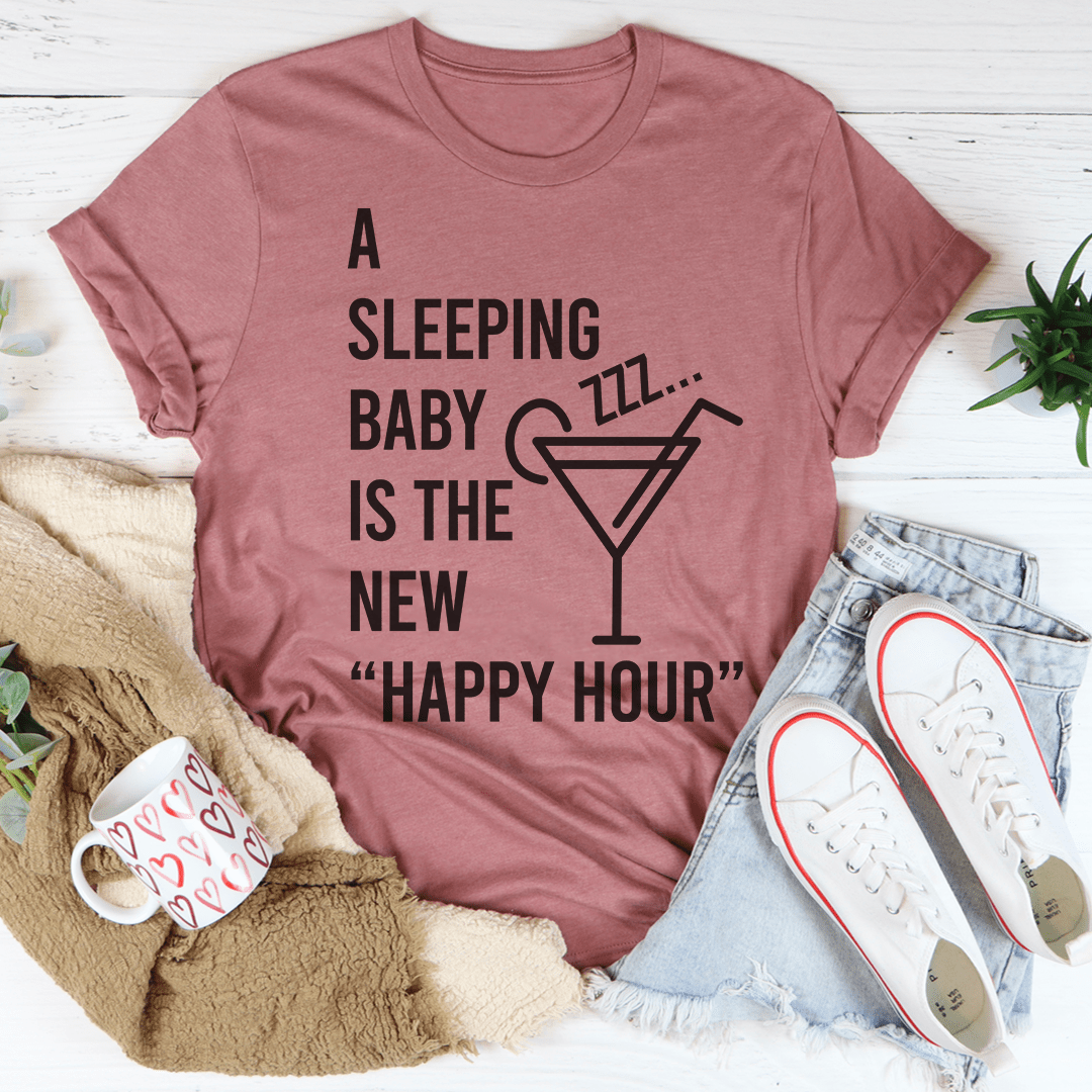 A soft and durable A Sleeping Baby Is The New Happy Hour Tee displayed on a hanger, showcasing its stylish design and quality fabric.