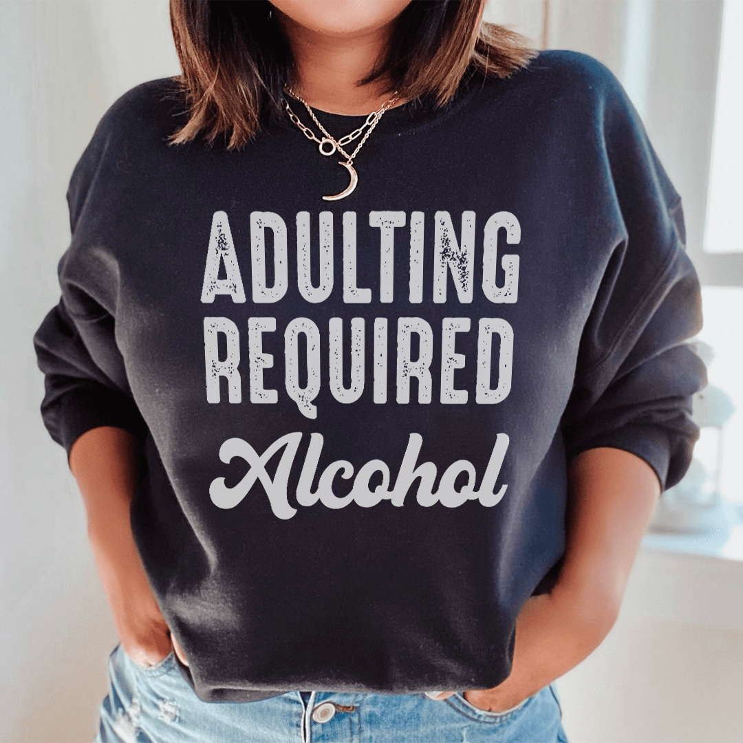 Cozy 'Adulting Requires Alcohol' hoodie featuring a humorous design, made from soft cotton/poly fleece blend.