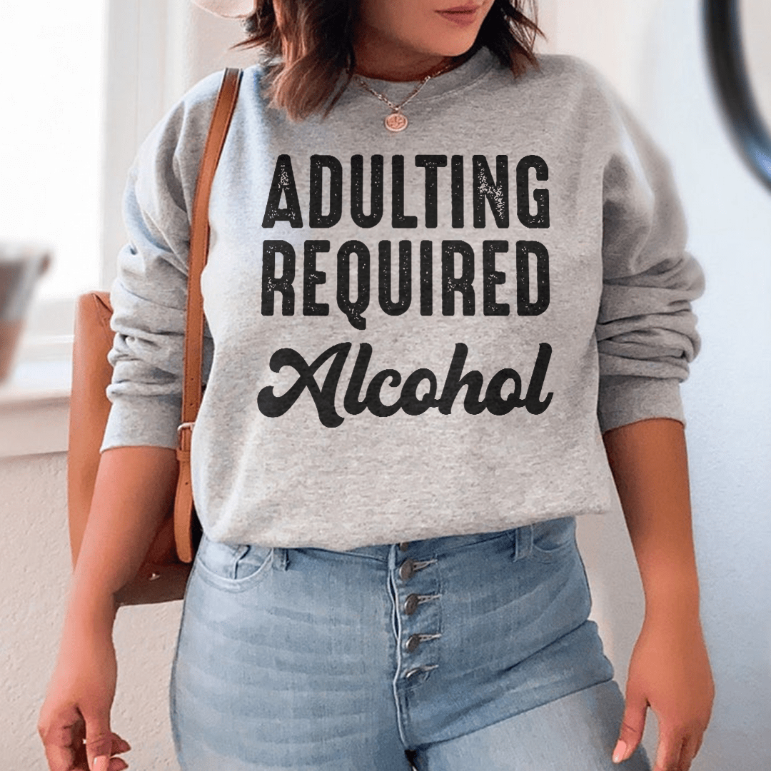 Cozy 'Adulting Requires Alcohol' hoodie featuring a humorous design, made from soft cotton/poly fleece blend.