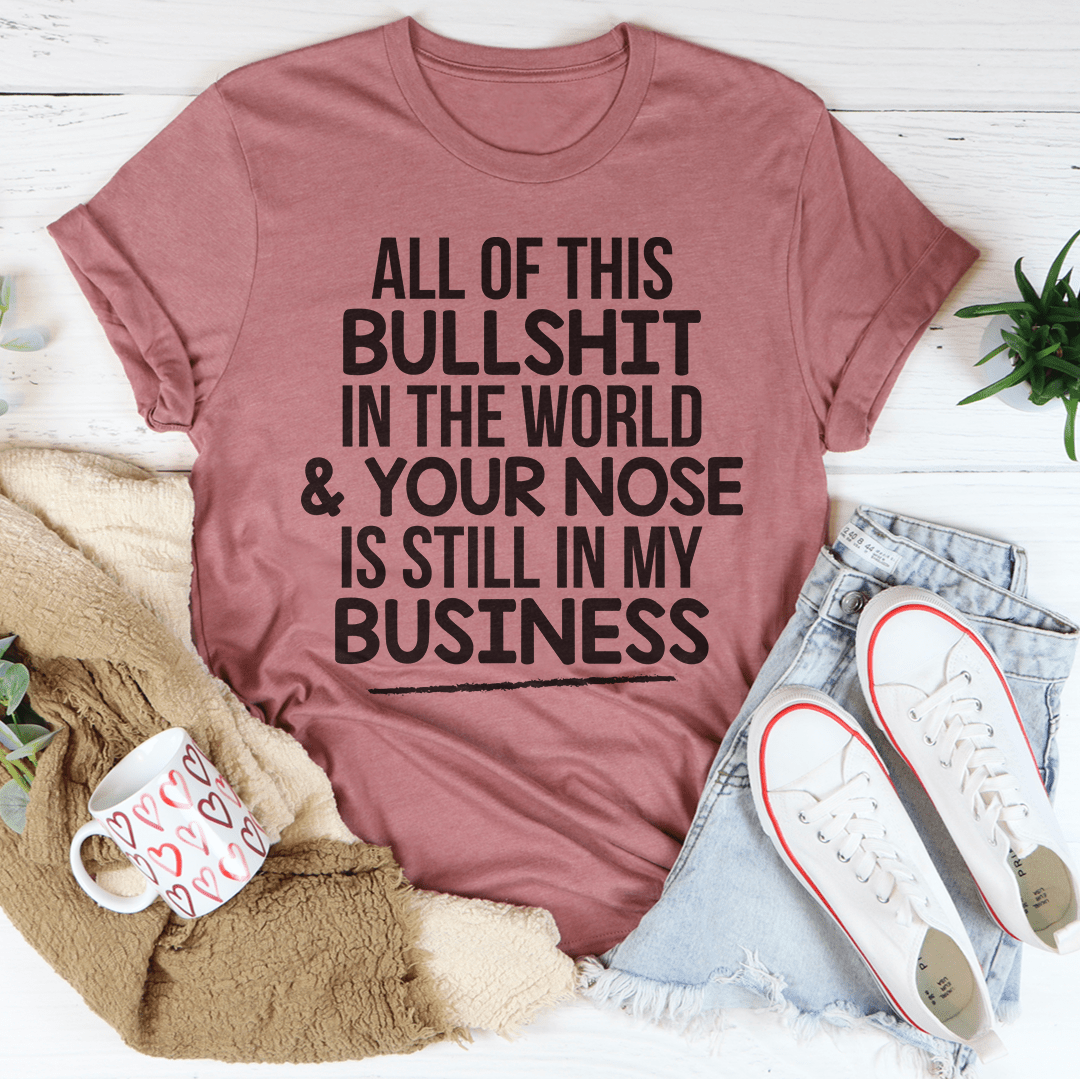 A stylish t-shirt featuring the phrase 'All Of This B.S In The World & Your Nose Is Still In My Business' printed on soft, durable cotton fabric.