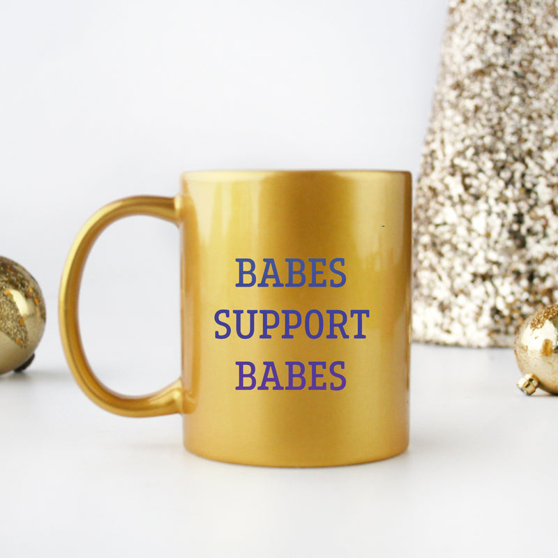 Babes Support Babes Gold & Silver Mug showcasing elegant design with gold metallic coating and ceramic material.