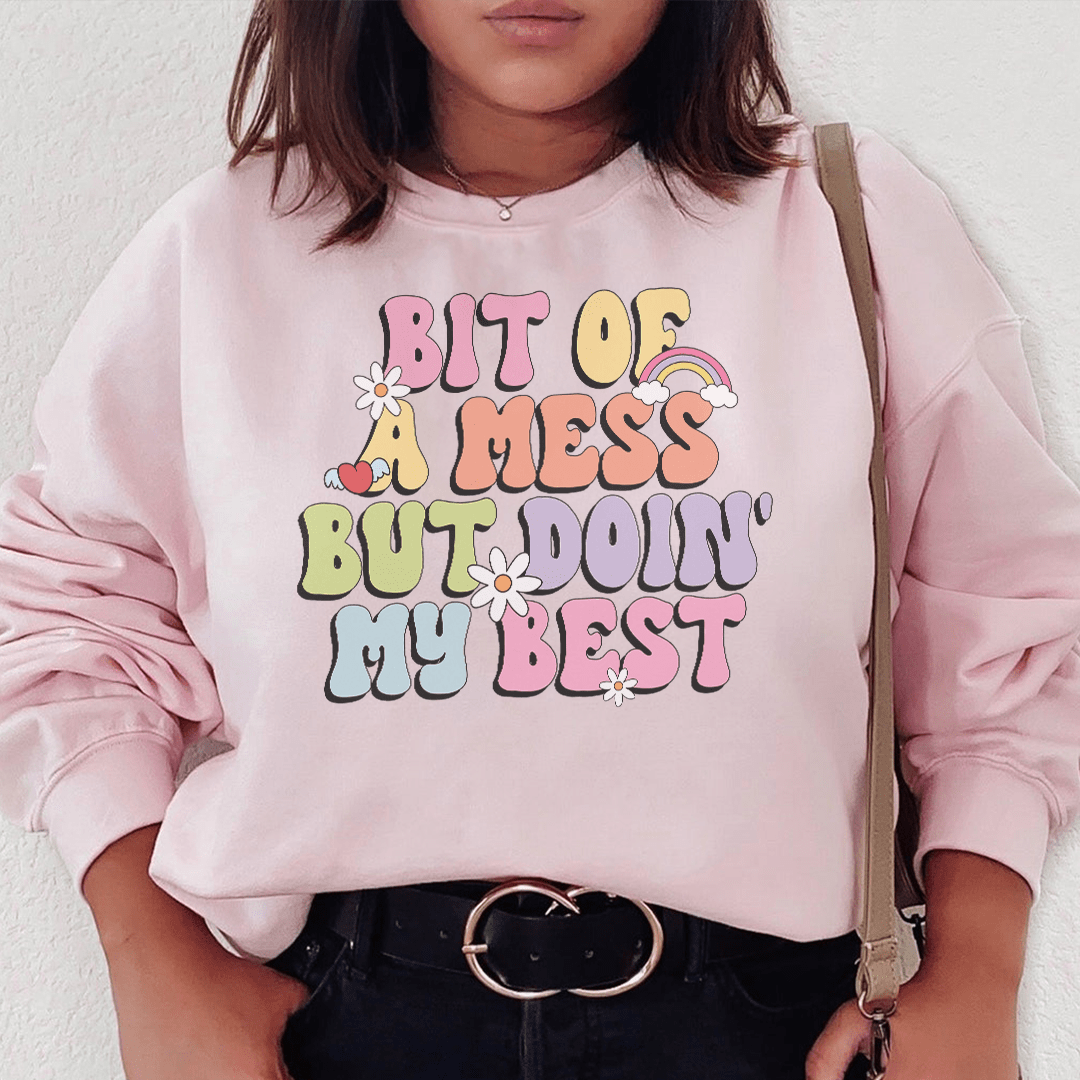 Cozy 'Bit Of A Mess But Doin My Best' sweats featuring a unique design by top artists, made from a warm cotton/poly fleece blend.