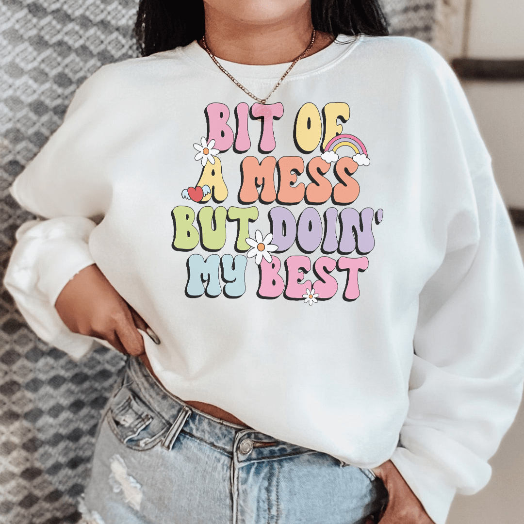 Cozy 'Bit Of A Mess But Doin My Best' sweats featuring a unique design by top artists, made from a warm cotton/poly fleece blend.