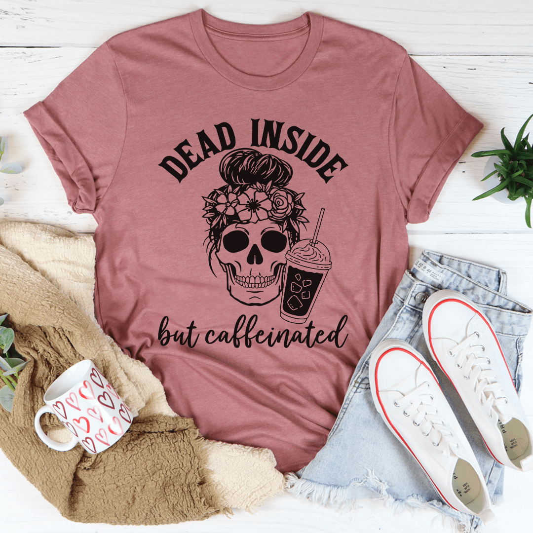 A black t-shirt with the phrase 'Dead Inside But Caffeinated' printed in white, showcasing a humorous design for coffee lovers.