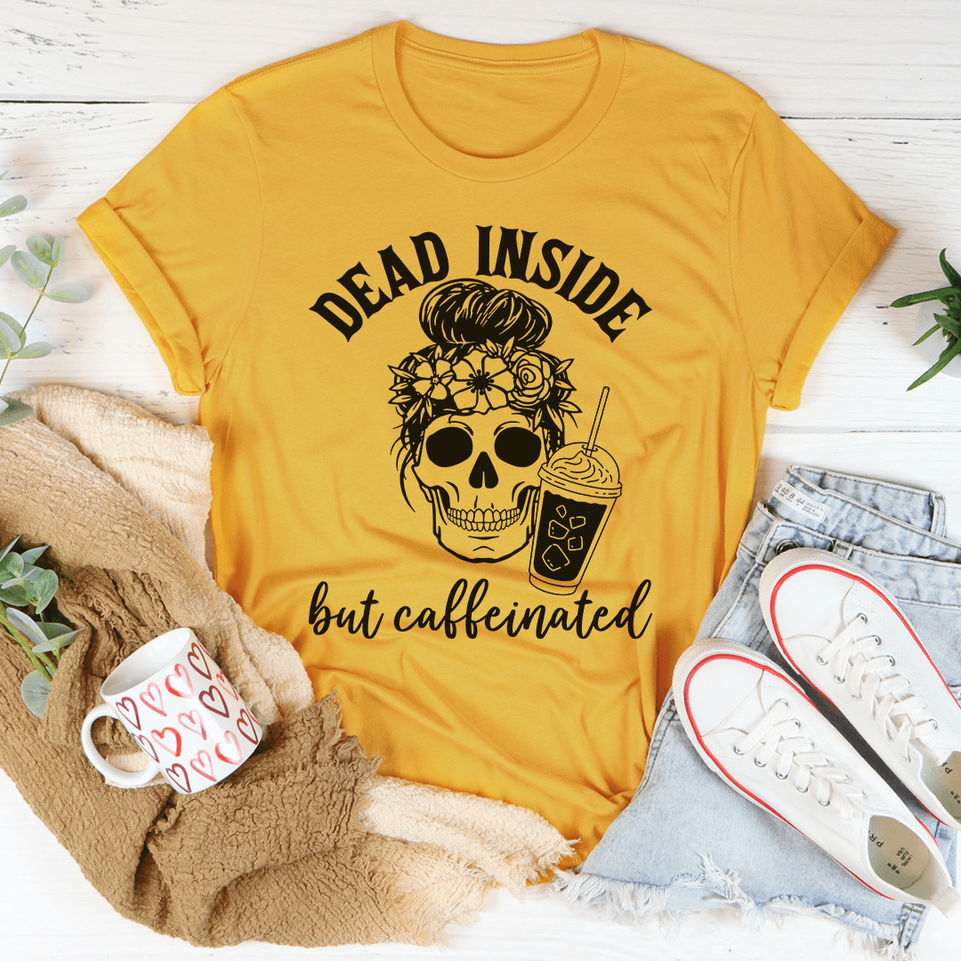 A black t-shirt with the phrase 'Dead Inside But Caffeinated' printed in white, showcasing a humorous design for coffee lovers.