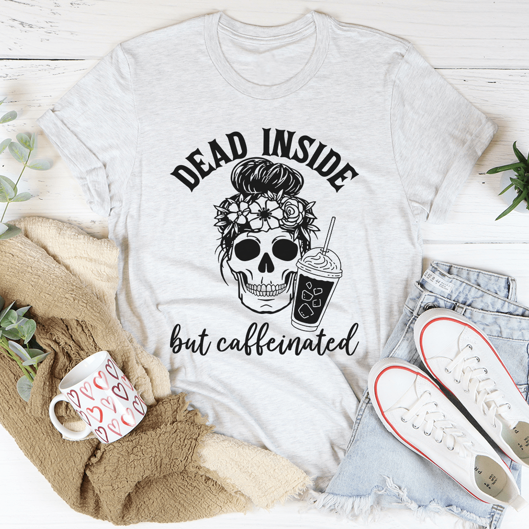 A black t-shirt with the phrase 'Dead Inside But Caffeinated' printed in white, showcasing a humorous design for coffee lovers.