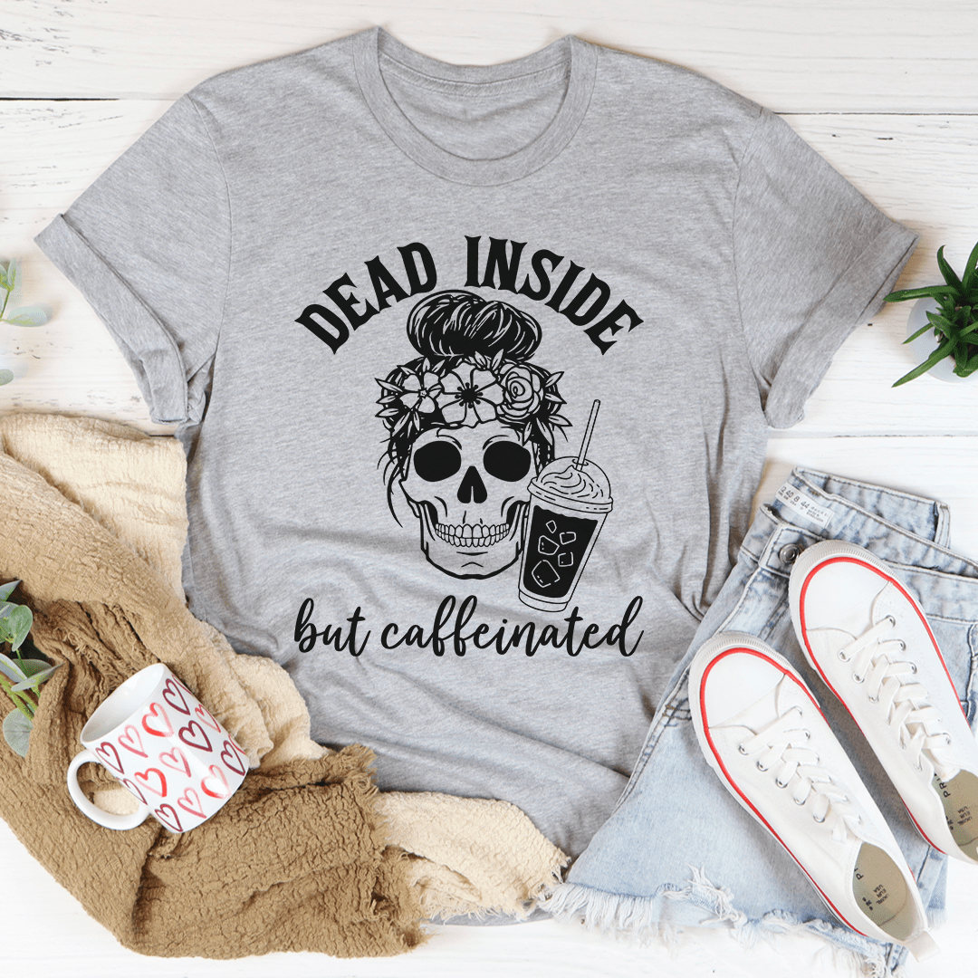 A black t-shirt with the phrase 'Dead Inside But Caffeinated' printed in white, showcasing a humorous design for coffee lovers.