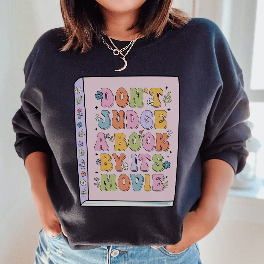 Cozy 'Don't Judge A Book' sweats featuring unique designs by top artists, made from cotton/poly fleece blend for ultimate comfort.