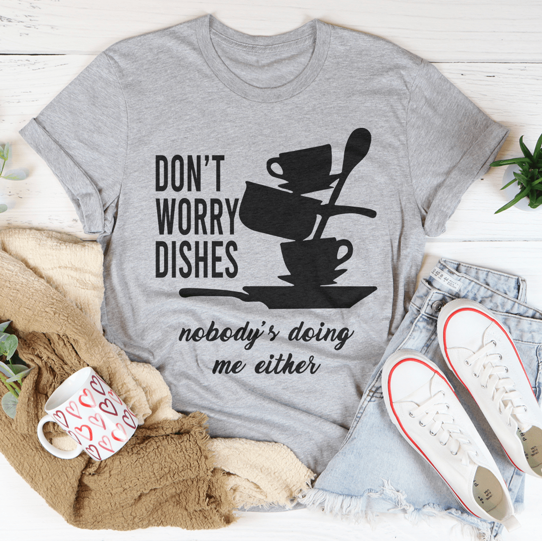 A comfortable Don't Worry Dishes Nobody's Doing Me Either Tee made from soft ring-spun cotton, featuring a playful graphic design.