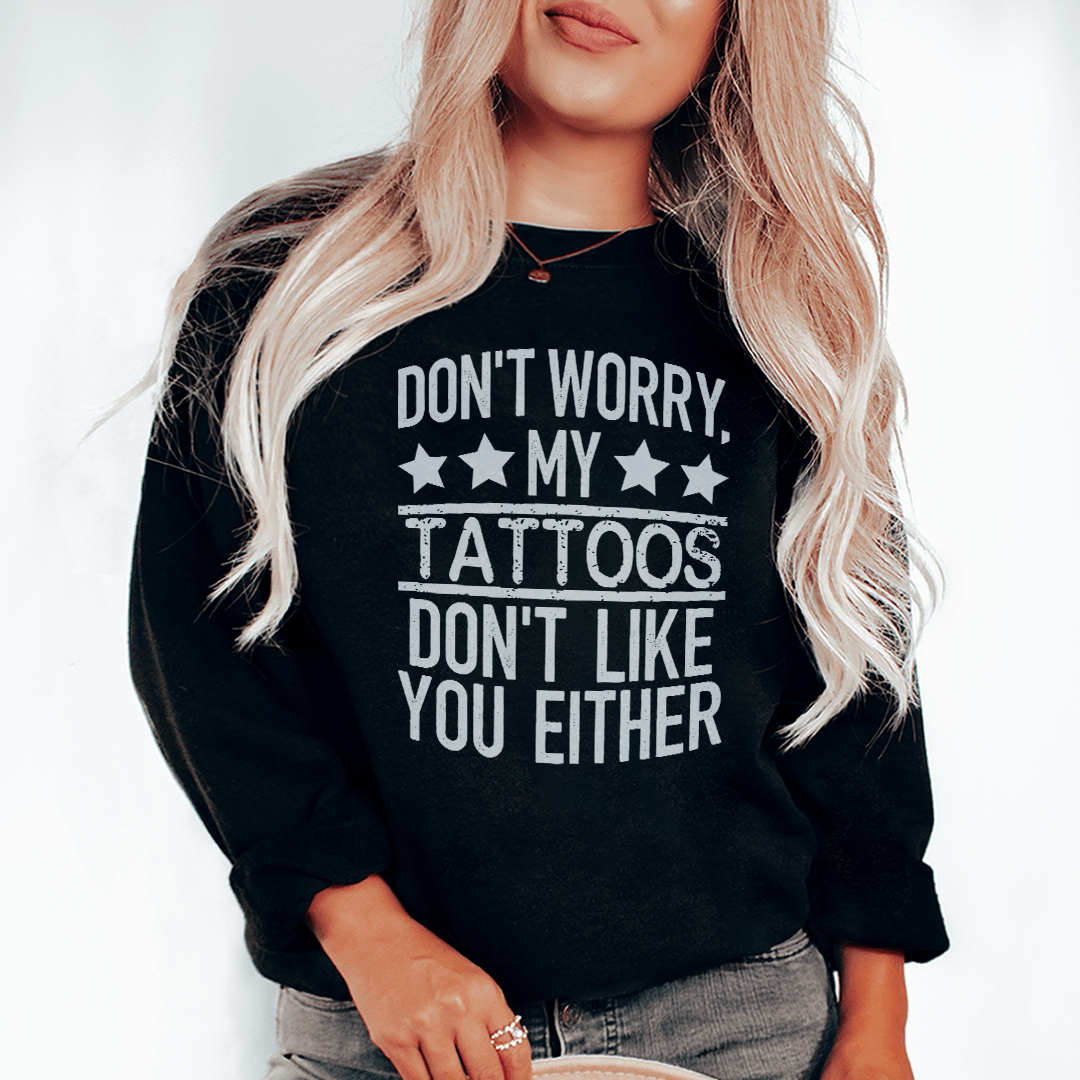 A cozy sweatshirt featuring the phrase 'Don't Worry My Tattoos Don't Like You Either', designed by top artists, showcasing a unique tattoo-inspired design.