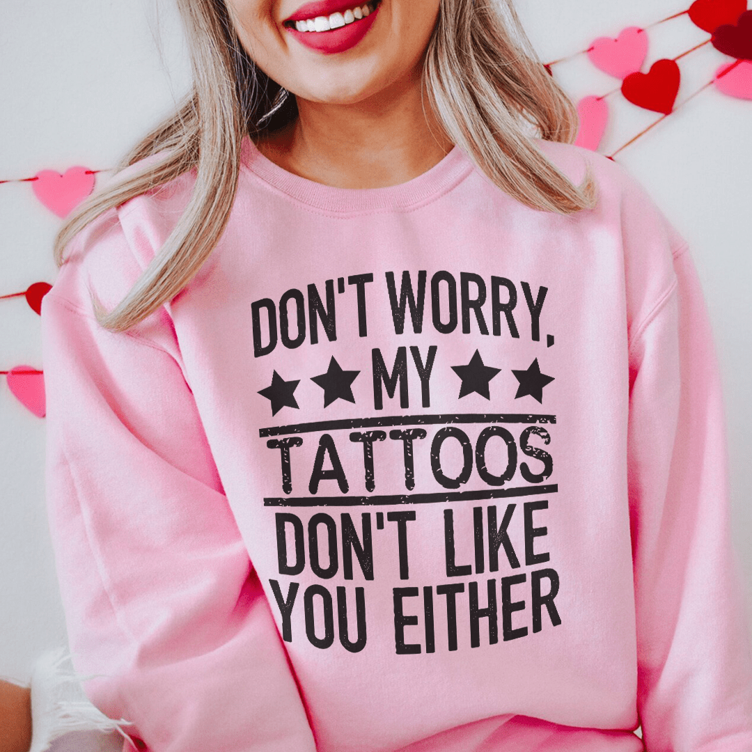 A cozy sweatshirt featuring the phrase 'Don't Worry My Tattoos Don't Like You Either', designed by top artists, showcasing a unique tattoo-inspired design.