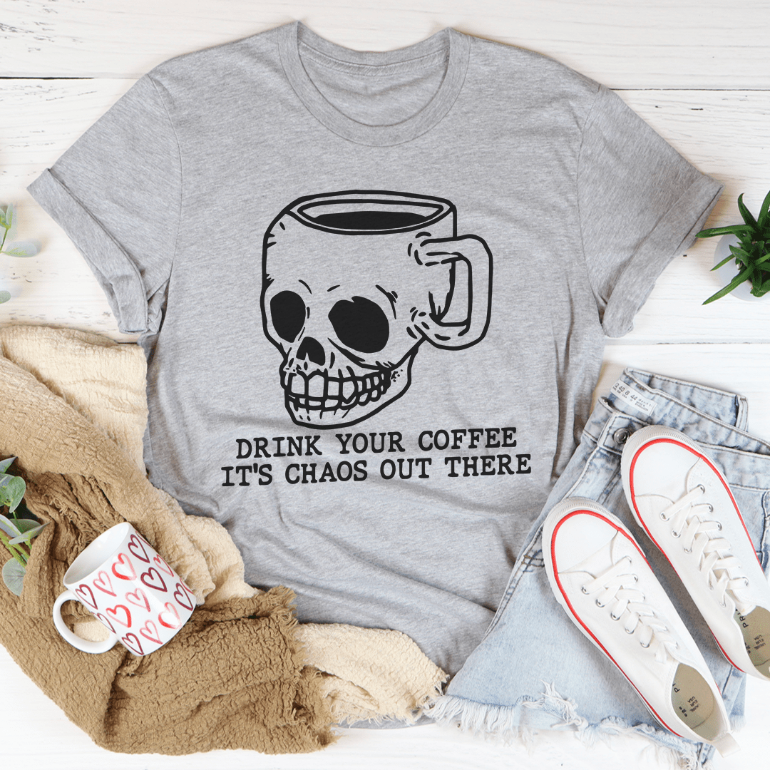 A stylish t-shirt featuring the phrase 'Drink Your Coffee It's Chaos Out There', made from soft ring-spun cotton with double stitching.