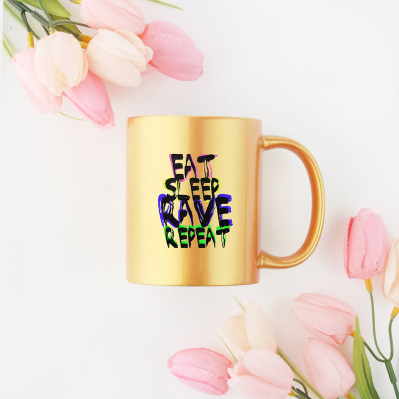 A stylish gold and silver ceramic mug featuring the phrase 'Eat Sleep Rave Repeat', perfect for rave enthusiasts.