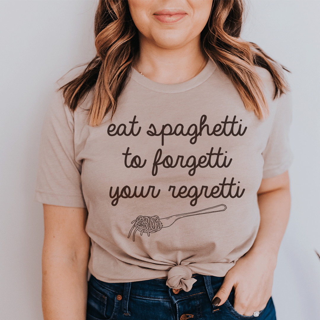 Eat Spaghetti To Forget Your Regretti T-Shirt displayed on a hanger, showcasing its soft cotton fabric and humorous design.