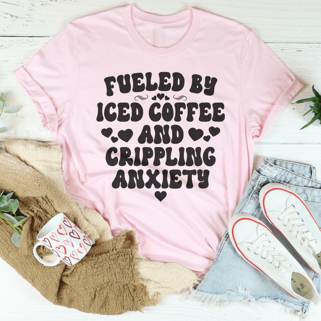 A stylish black t-shirt featuring the phrase 'Fueled By Iced Coffee And Crippling Anxiety' printed in bold, eye-catching letters.