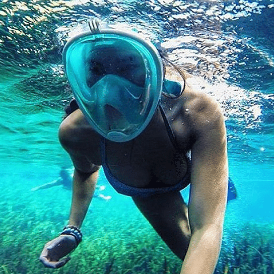 A full face snorkel mask with a transparent visor, designed for 180-degree views, featuring adjustable straps and a ventilated storage bag.